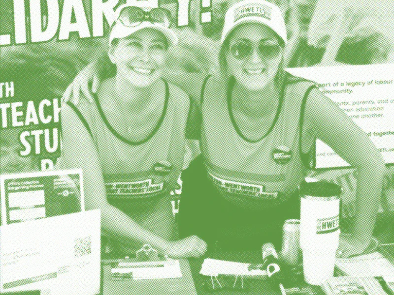 Photo of HWETL members at a public event with a table of resources and outreach information.